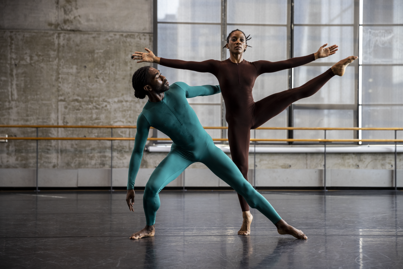 Jacquelin Harris is downstage, one leg lifted to the side, arms extended in a V forward. Chalvar Monteiro lunges to the side of her, one land resting on her back.  
